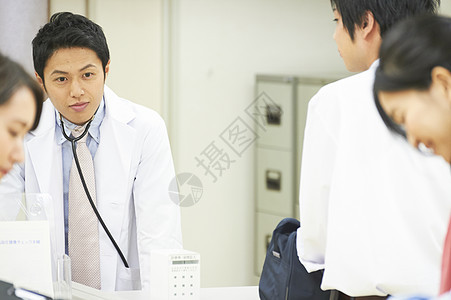 医院服务台旁的医生跟前来就诊的病人图片
