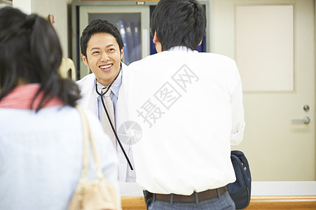 医院服务台旁的医生跟前来就诊的病人图片