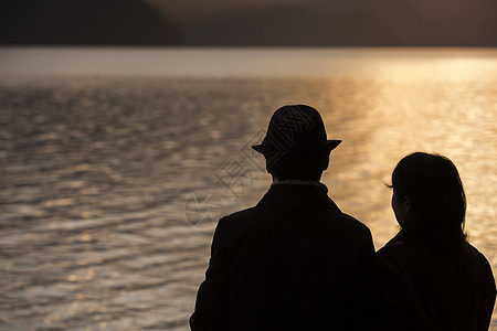  海边夕阳下牵手的夫妻图片