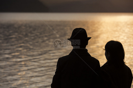  海边夕阳下牵手的夫妻图片