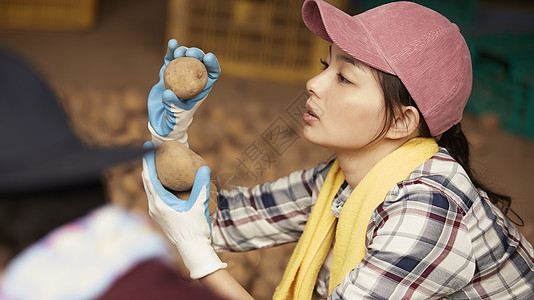 手拿土豆的年轻女人图片