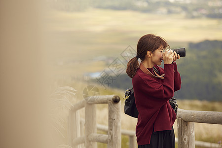 女性青年在户外旅游观光拍照图片