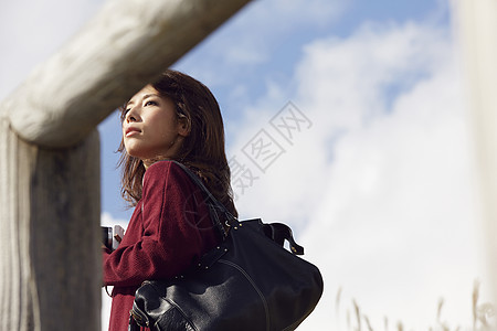 女性青年在户外旅游观光拍照图片