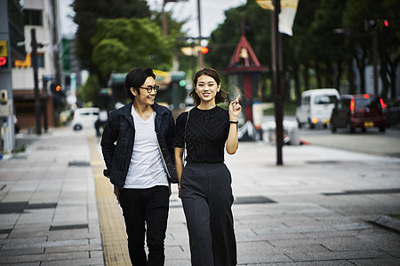 恋爱唯美一对在城市街边散步的情侣背景