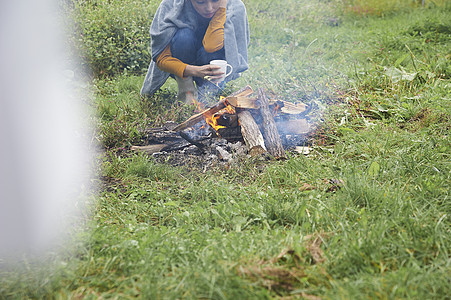 坐在篝火旁的女人图片