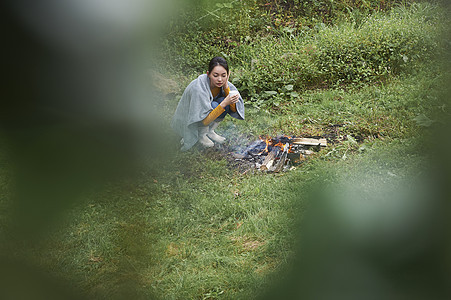 户外在篝火旁的女人图片