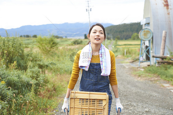 女人在田间小路上推着独轮车图片