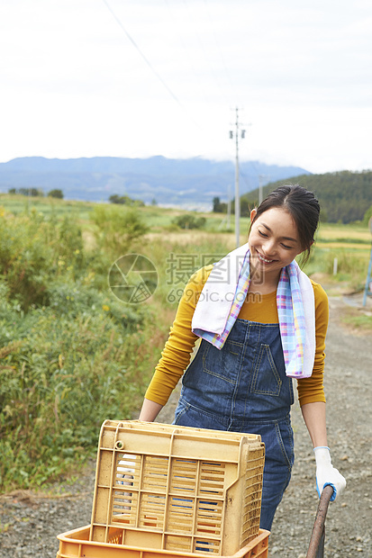 女人在田间小路上推着独轮车图片