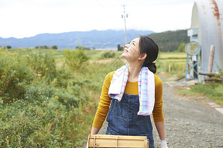 女人在田间小路上推着独轮车图片