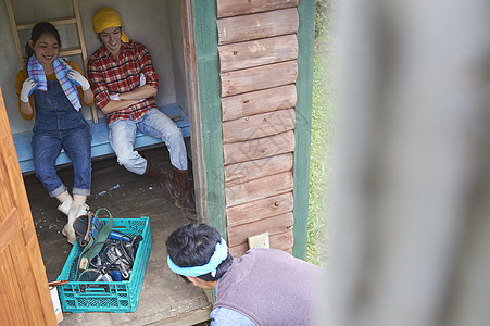 蹲下木匠工具男子做diy的朋友正在休息图片