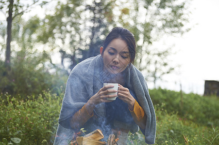 披着毯子拿着杯子的女人图片