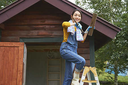 在梯子上装修房屋的女人图片