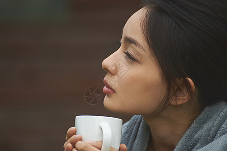 披着毛毯喝咖啡的女性图片