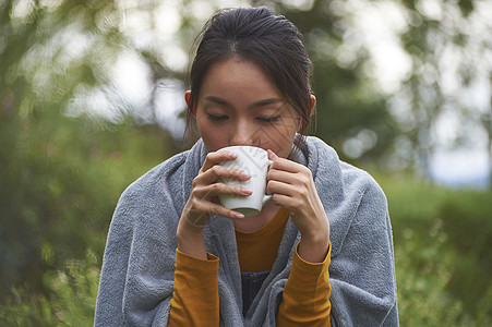 丰胸美容露营时喝咖啡的女性背景