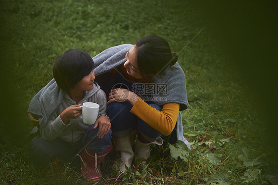 母亲和孩子在户外烤火图片