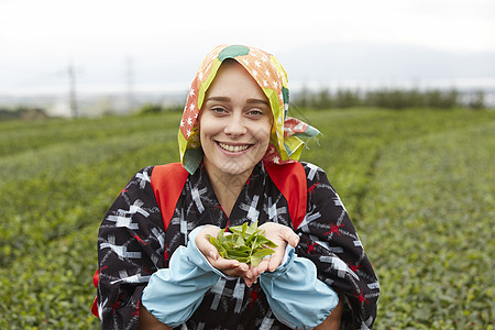  双手捧茶叶的外国女性图片