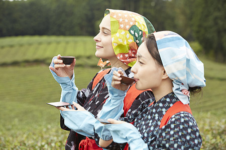 品味新鲜茶叶的女子图片