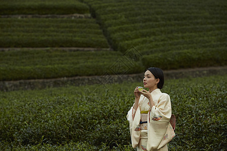 手捧茶杯的优雅妇女图片