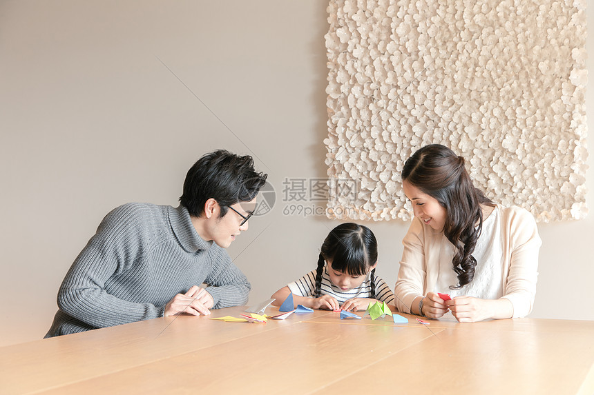一家三口坐在桌前玩亲子游戏图片