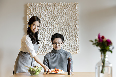 妻子把做好的菜端上家中饭桌图片