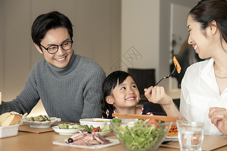 幸福的夫妻带孩子在家里吃饭图片