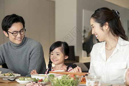 幸福的夫妻带孩子在家里吃饭图片