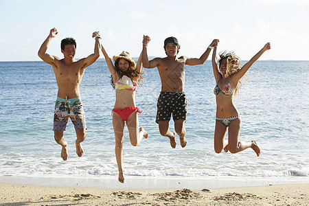 在夏威夷海边开心的跳起来的年轻人图片