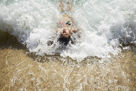 海滩上被浪花打中的少女图片