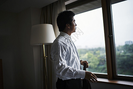 站在旅馆窗口的一个商人图片