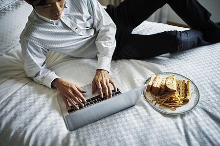 早餐时间在床上工作的商务人士图片