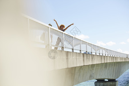  桥上挥手的女性图片