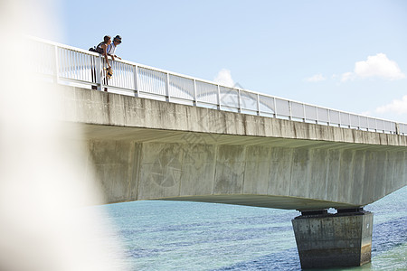 在海边的桥上散步的情侣图片