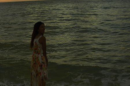  傍晚站在海边的女性图片