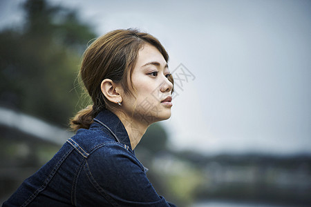 坐在河岸边发呆的年轻女孩图片素材