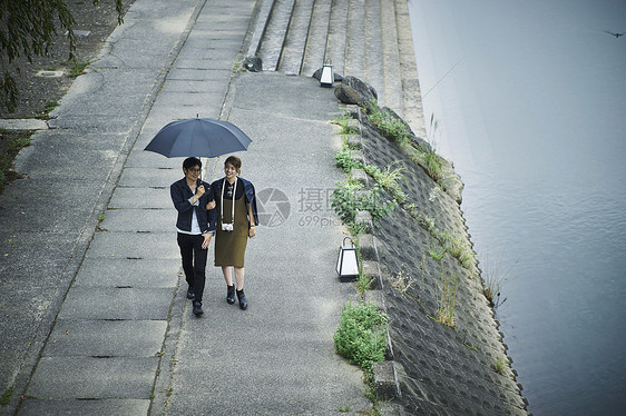 夫妇旅行雨中漫步照图片