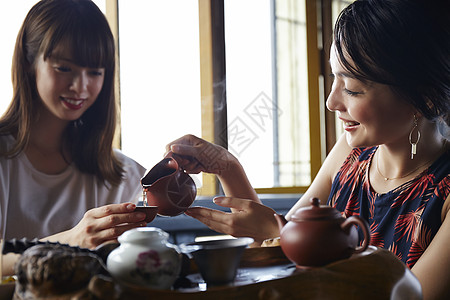 女人给朋友倒茶图片