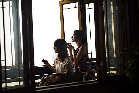 女人在茶馆窗台边喝茶图片