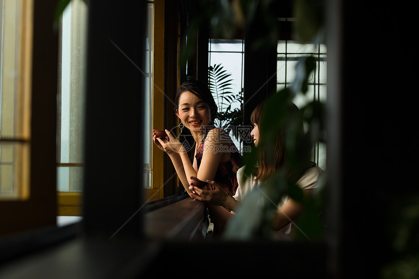 女人在茶馆窗台边喝茶