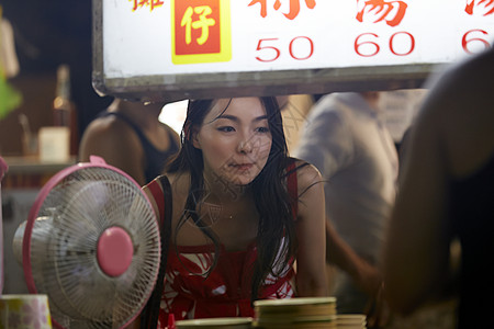 在夜市品尝美食的女性图片