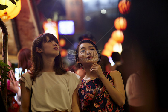 两个女游客在夜市里逛街图片