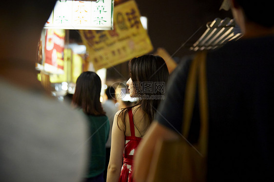 在夜市逛街的女游客背影图片