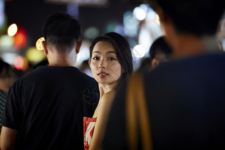 在夜市逛街的女游客回头看镜头图片素材