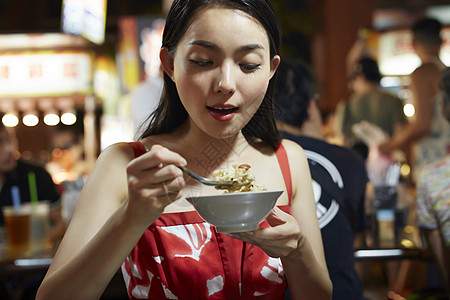 在夜市逛街的女游客吃小吃图片素材