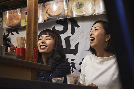 喝清酒吃烧烤的女游客在大笑福冈图片