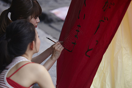 两个女游客在祈福灯笼上写字图片