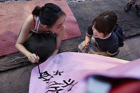 两个女游客在祈福灯笼上写字图片