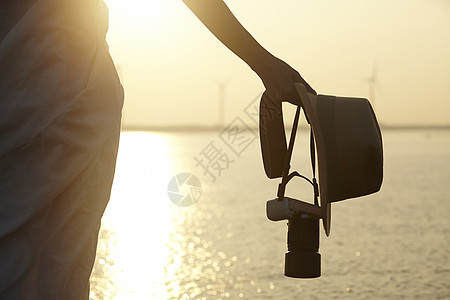 湿地旅游的女性手持相机帽子特写图片