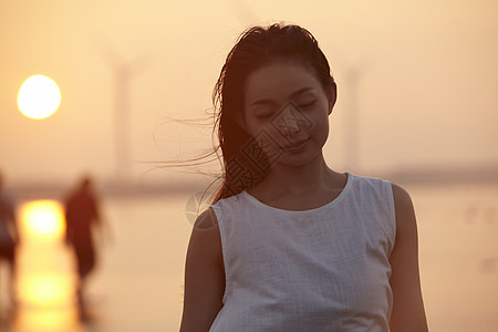 日落时分走在海滩边上长裙美女图片