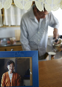 老妇人照片后面独居的老人在厨房给速食产品倒水图片