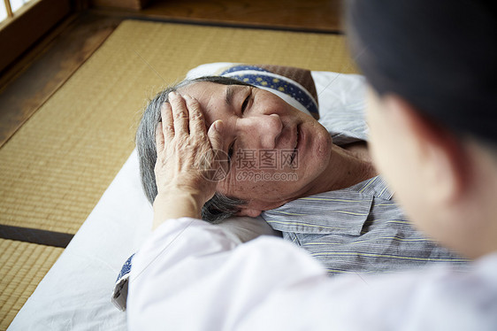 老妇人照顾躺在床上的老男人图片